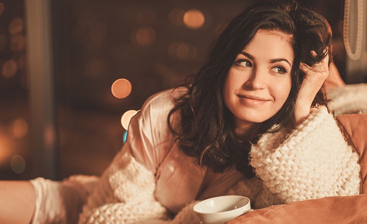 Frau trinkt Tee auf der Couch